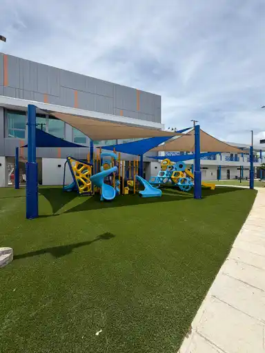 Área infantil con juegos y grama artificial