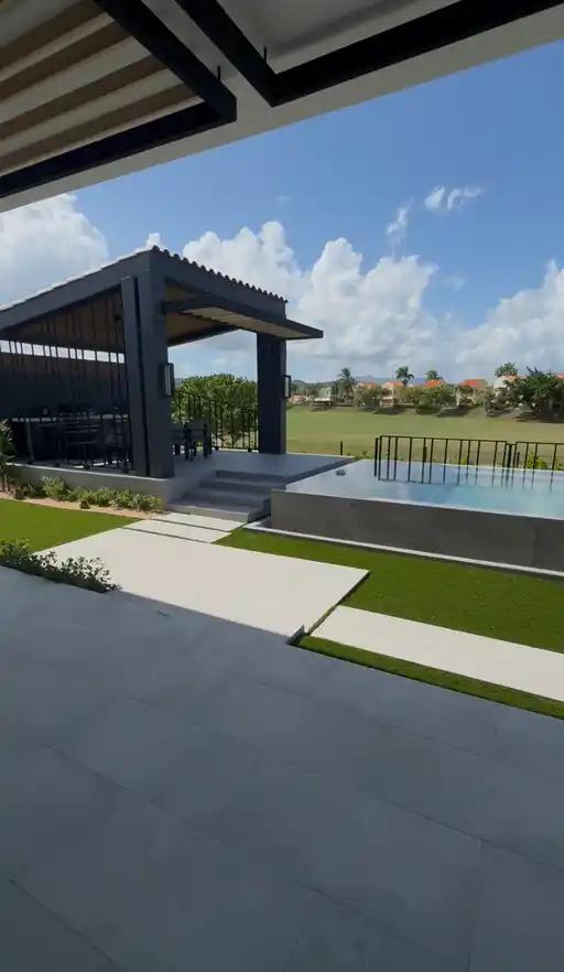 Terraza moderna con piscina y detalles de grama artificial